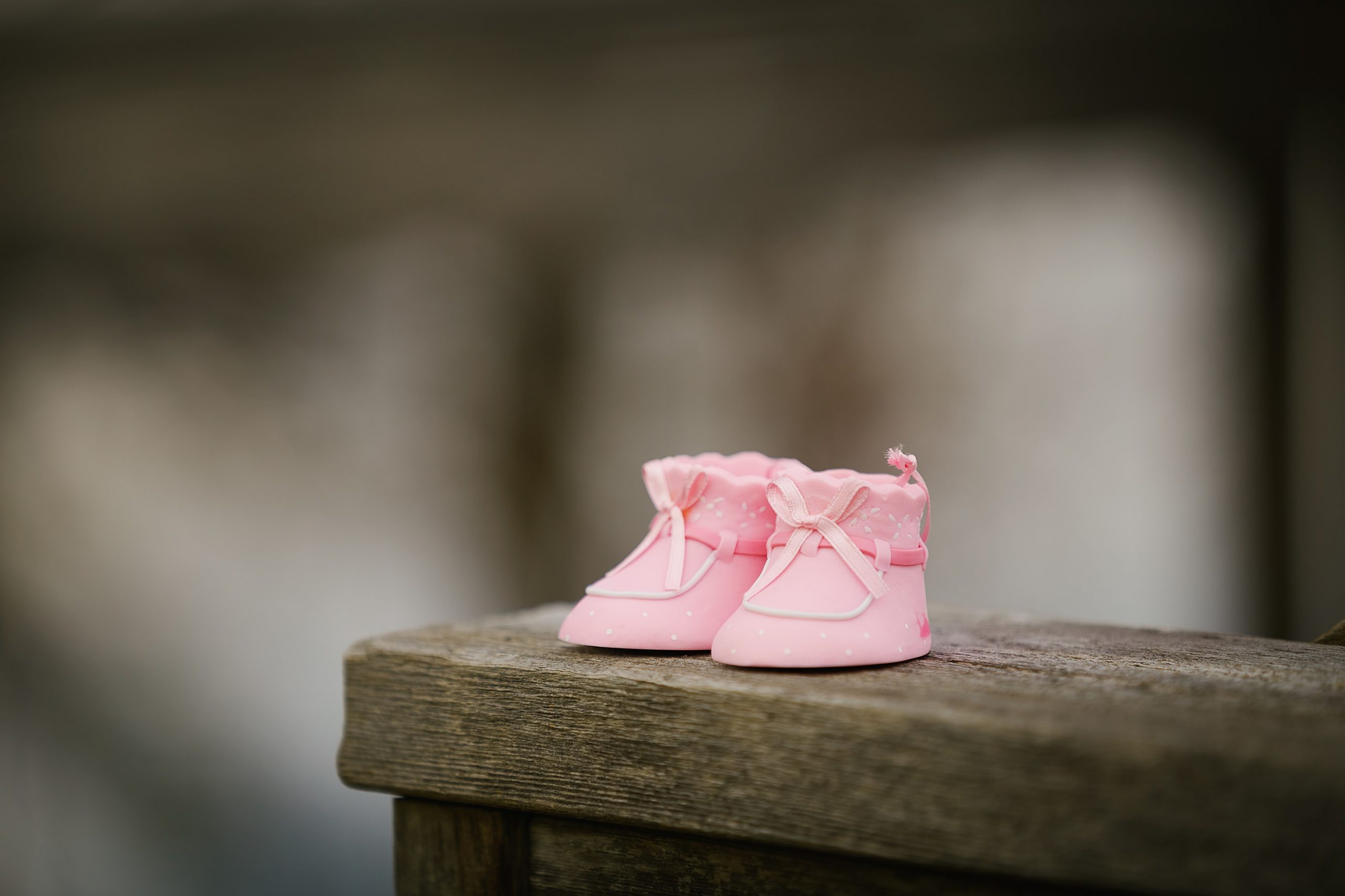 Little pink booties on a bench